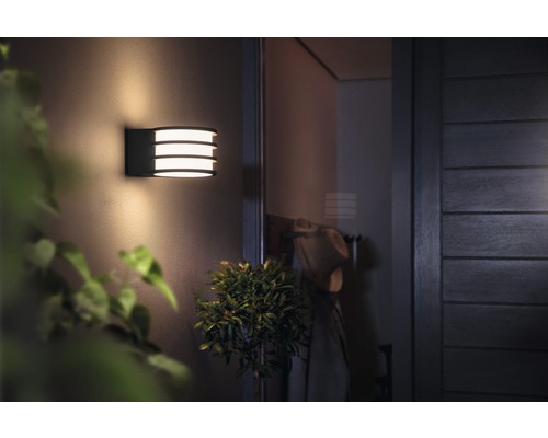 Osvetlené vonkajšie nástenné svietidlo s tromi žiarovkami.