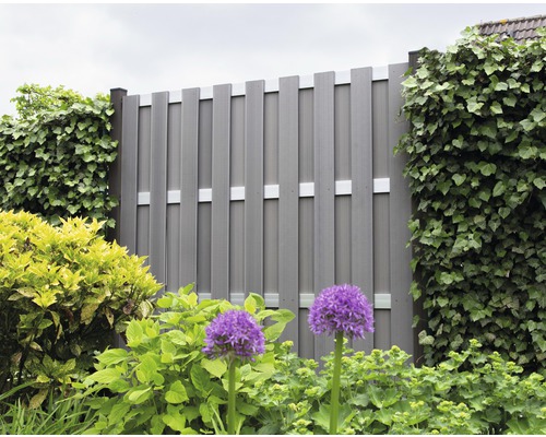 Pohľad do záhrady so sivým plotom na ochranu súkromia a rastlinami