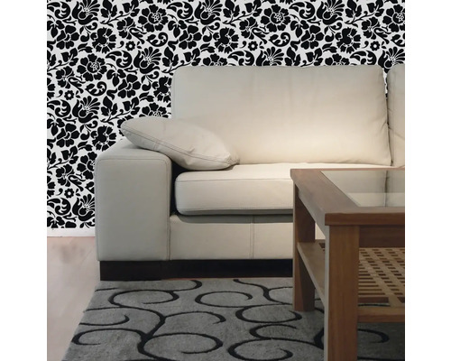 Obývacia izba s pohovkou, dreveným stolom, vzorovaným kobercom a kvetinovou tapetou