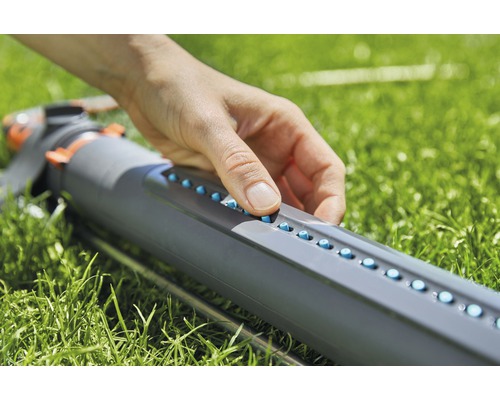 Osoba nastavuje trysky zavlažovača.