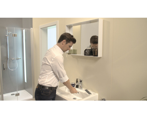 Moderná kúpeľňa s umývadlom, zrkadlom a sprchou.