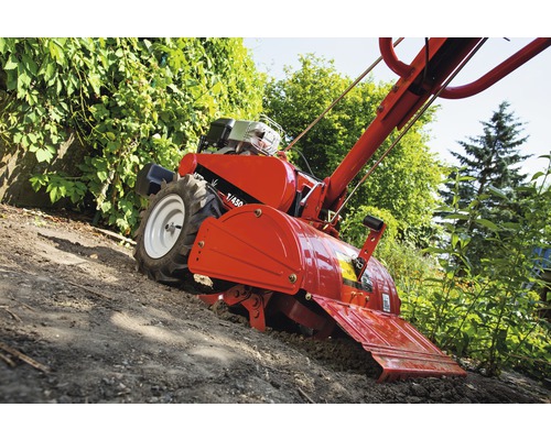 Motorový kultivátor pri spracovaní pôdy v záhrade.