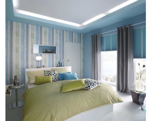 Svetlá spálňa s manželskou posteľou, vzorovanou tapetou a oknom so závesmi a žalúziami