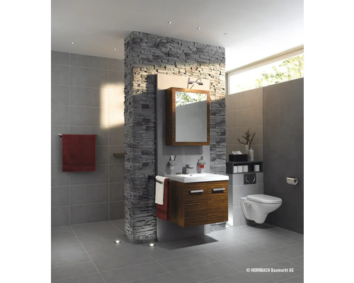 Kúpeľňa s umývadlom, zrkadlom, toaletou a obkladom stien s kamenným vzhľadom