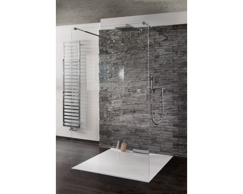 Sprchovací kút v úrovni podlahy so sklenenou stenou a kamennou stenou