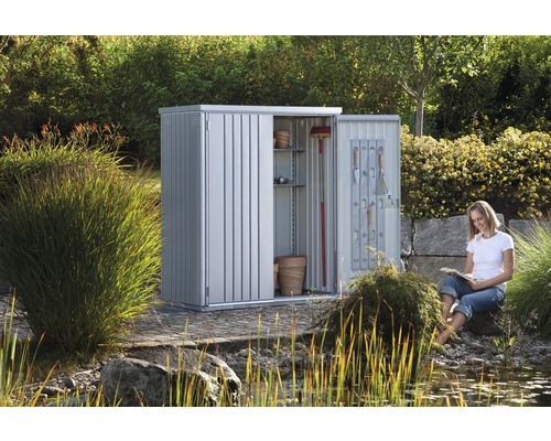 Kovová záhradná skriňa s otvorenými dverami a žena v záhrade