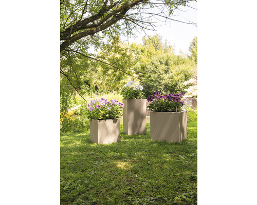 Tri osadené kubické kvetináče v záhrade.