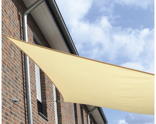 Trojuholníková slnečná plachta upevnená na stene domu