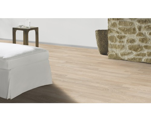 Svetlá laminátová podlaha v obývacej izbe s pohovkou, stolom a kamennou stenou