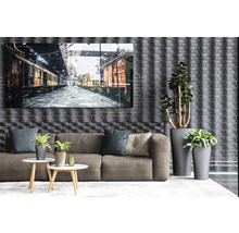 Obývacia izba s pohovkou, konferenčnými stolíkmi, črepníkovými rastlinami a zarámovaným obrázkom vlakových vozňov