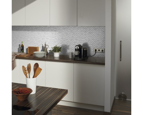 Moderná kuchyňa s bielymi skrinkami, mozaikovými obkladmi a drevenou pracovnou doskou