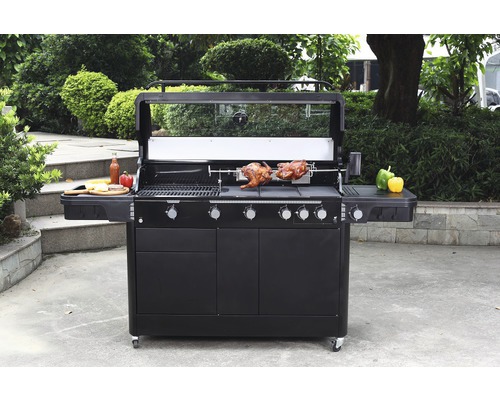 Veľký gril s funkciou otočného ražňa, grilované jedlo a odkladacie plochy vo vonkajšom prostredí