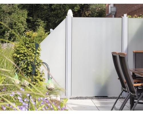 Záhradná scéna so zástienkou, stolom a stoličkami na terase.