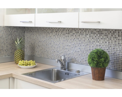 Kuchynský drez s batériou, mozaikové obklady, ananás, hrozno a črepníková rastlina na pracovnej doske