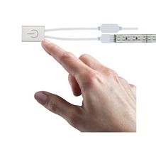 Ruka sa dotýka spínača pre LED pásiky.