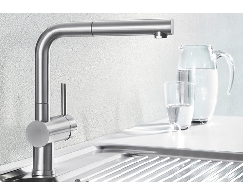 Kuchynská batéria z nehrdzavejúcej ocele vedľa drezu a džbánu na vodu