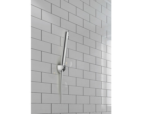 Ručná sprcha s nástenným držiakom pred obkladanou stenou