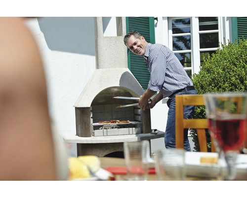 Muž griluje jedlo vonku so záhradným grilom