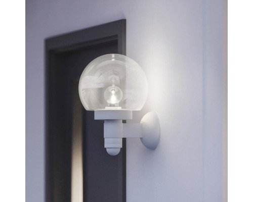 Nástenné svietidlo s okrúhlou sklenenou guľou v svetlej miestnosti vedľa dverí