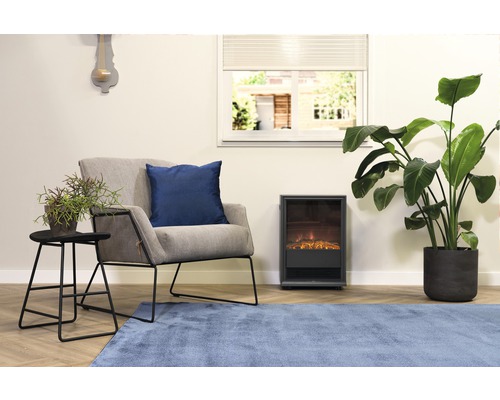 Obývacia izba s kreslom, vankúšom, stolom, izbovými rastlinami, elektrickým krbom a kobercom