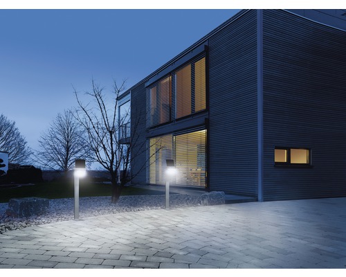 Osvetlená cesta s vonkajšími svetlami pred domom