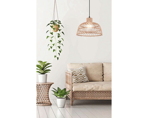 Obývacia izba s ratanovou pohovkou, príručným stolíkom, závesnou lampou a izbovými rastlinami