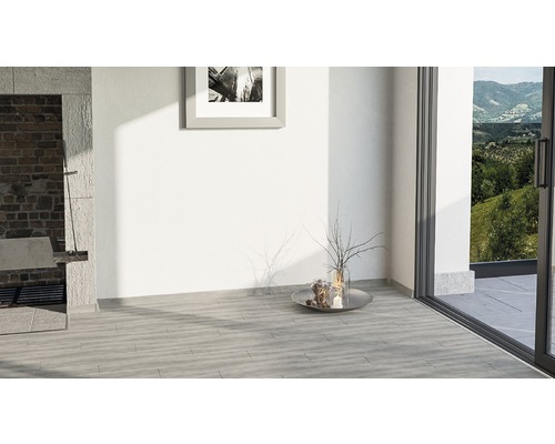 Svetlá miestnosť s dlaždenou podlahou, terasovými dverami a murovaným grilom