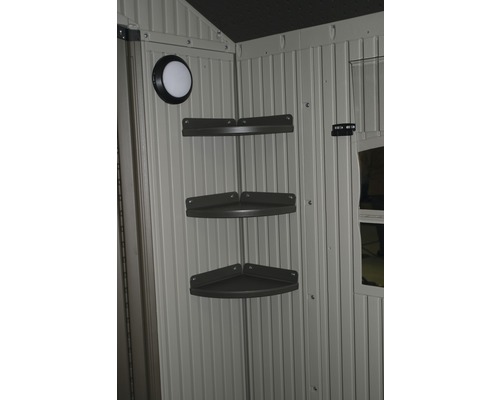 Vnútorný pohľad na záhradný domček s rohovou policou a svetlom