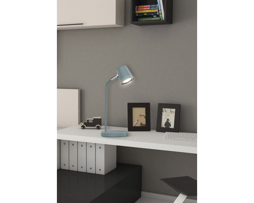 Písací stôl so stolnou lampou, rámčeky na fotografie a dekorácie