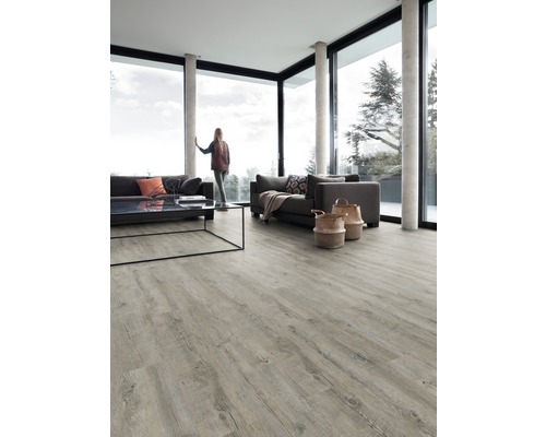 Svetlá obývacia izba s veľkým oknom, pohovkami, stolom a svetlou drevenou podlahou