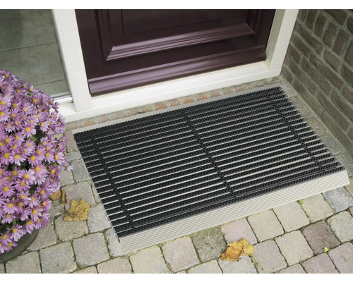 Čistiaca rohožka pred vchodovými dverami s kvetmi