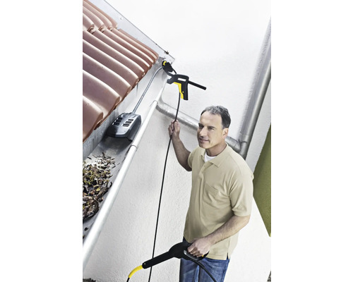 Muž čistí odkvap pomocou čističa odkvapov