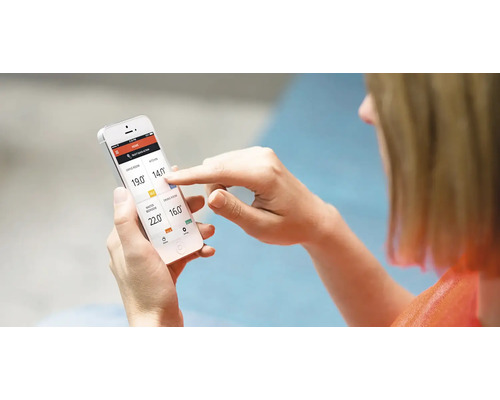 Žena ovláda smartfón s aplikáciou regulátora teploty