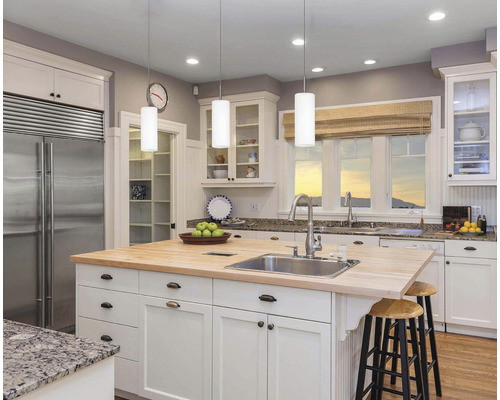 Svetlá kuchyňa s kuchynským ostrovom, umývadlom, batériou a posedením.