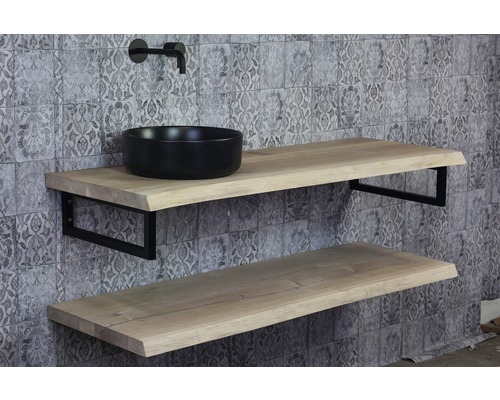 Kúpeľňa s dvoma drevenými policami, čiernym umývadlom na dosku a batériou pred stenou so vzorom