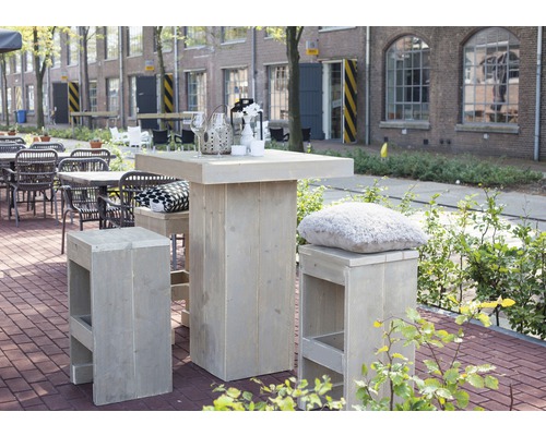 Scéna s dreveným barovým stolom a barovými stoličkami vonku.