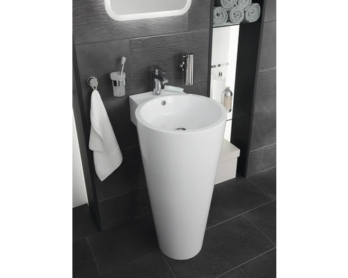 Kúpeľňa s voľne stojacim umývadlom, batériou, držiakom na uteráky a doplnkami.