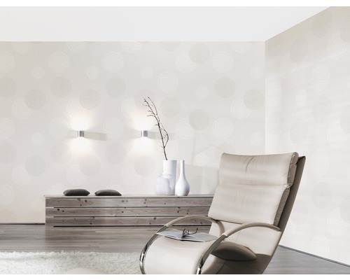 Obývacia izba s tapetou so vzorom, kreslom a drevenou komodou