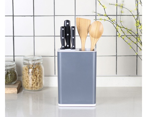 Blok na nože s nožmi a drevenými vareškami na kuchynskej linke