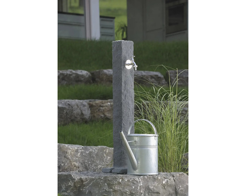 Záhradná scéna s kamenným odberným miestom vody a kanvou