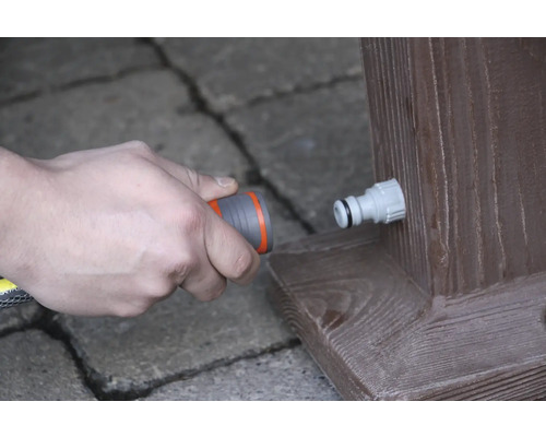 Pripojenie záhradnej hadice k vodovodnému kohútiku na drevenom tráme