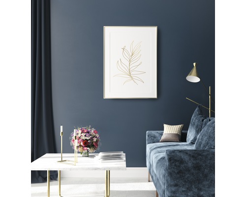 Obývacia izba s pohovkou, stolom a zarámovaným obrázkom rastliny