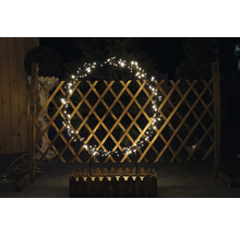 Dekoratívny svetelný kruh na drevenom plote s kvetináčom