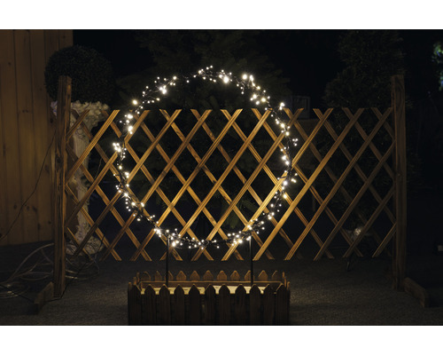 Dekoratívny svetelný kruh na drevenom plote s kvetináčom