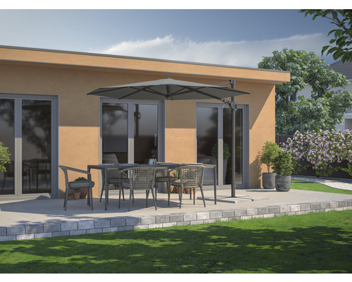 Terasa s jedálenským stolom, stoličkami a slnečníkom pred budovou