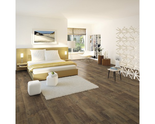 Spálňa s laminátovou podlahou v drevenom vzhľade, posteľou a bielym nábytkom