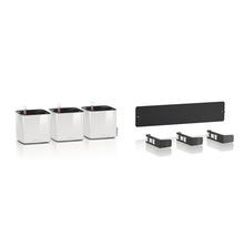 Tri biele kvetináče so zavlažovacím systémom a príslušenstvom na montáž na stenu.