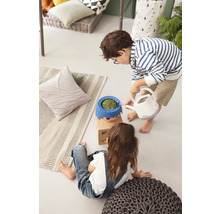 Dve deti v interiéri, jedno zalieva rastlinu v kvetináči s tvárou kanvou.