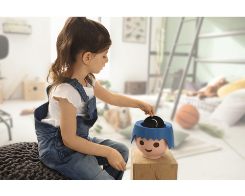 Dievča sa hrá s prasiatkom v detskej izbe