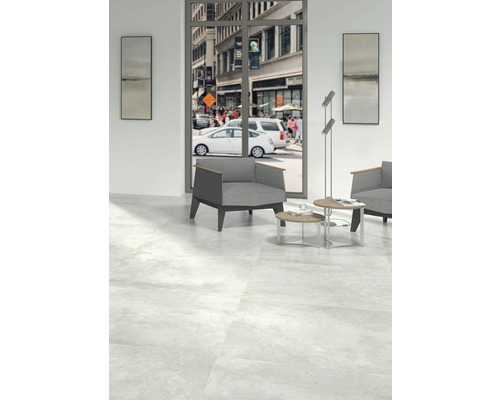 Svetlá miestnosť s podlahovými dlaždicami, kreslom a výhľadom na rušnú mestskú ulicu.